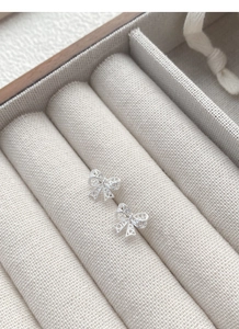 Dettaglio degli orecchini a fiocco in argento S925 con delicati motivi a cuore traforati