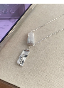 Dettaglio della collana in argento S925 con perla barocca e ciondolo in metallo ondulato