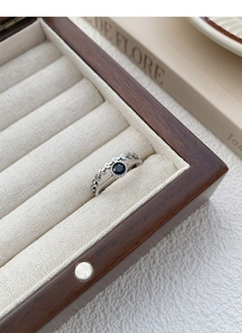 Makroaufnahme von S925 Sterlingsilber Weizenring mit schwarzem Edelstein auf Holz