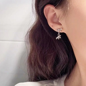 Elegant S925 sterling silver double bow earrings shown on model for women