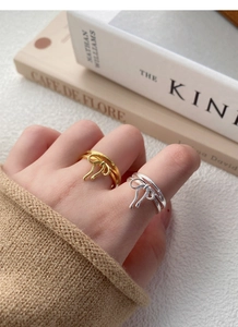 Detail of minimalist S925 sterling silver bow rings in gold and silver finish