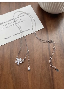 Macro detail of S925 sterling silver butterfly and flower pendant with clear crystals