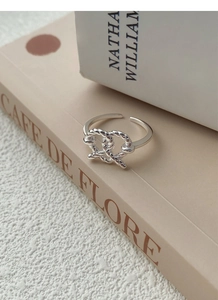Detailed view of S925 sterling silver twisted weave ring on a minimalist book background