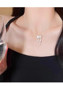 Gros plan du pendentif papillon en argent S925 élégant porté par un modèle féminin