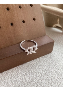 Macro view of the S925 sterling silver woven knot ring with detailed metal hallmark