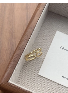 Detail of a golden double-layer open ring featuring a row of small metal beads and a thin band