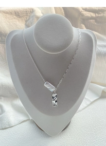 Dettaglio collana in argento S925 con perla barocca e ciondolo in metallo irregolare