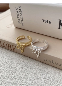 Detailed close-up of S925 sterling silver bow rings in gold and silver finishes