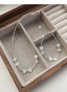 Détail du collier en argent S925 avec breloques en nacre blanche en forme de cœur en boîte