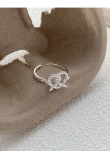 Close-up of S925 sterling silver twisted knot ring with a polished open adjustable band