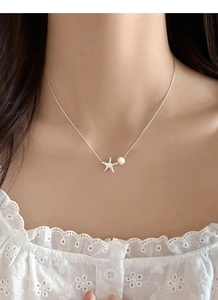 Détail du pendentif étoile de mer en argent S925 avec zircon et perle sur le cou