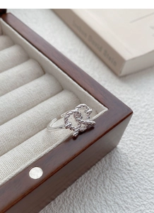 Detailed macro view of S925 silver twisted rope pretzel ring on vintage jewelry box