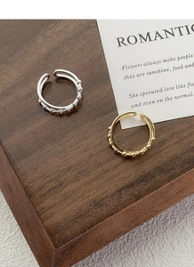 Detailed macro view of S925 sterling silver bead cross rings in gold and silver finishes