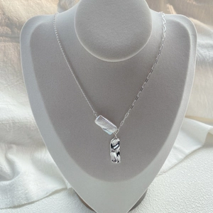 Collana in argento S925 con perla barocca e catena asimmetrica su busto per gioielli grigio