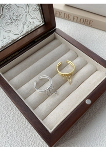 Detailed shot of gold and silver S925 sterling silver bow rings in a wooden jewelry box