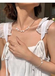 Détail du collier et bracelet en argent perlé avec pendentif cœur en nacre sur modèle