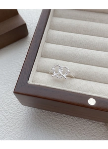 Close-up of S925 sterling silver pretzel knot ring with woven rope texture on wood box
