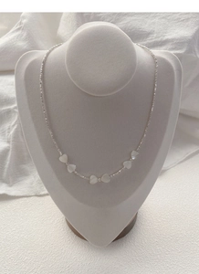 Vue détaillée du collier en argent S925 avec cinq pendentifs cœurs en nacre blanche