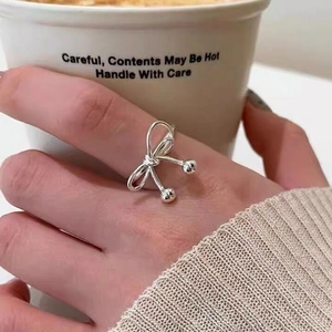 Minimalist S925 sterling silver bow ring with irregular lines and small beads on a hand