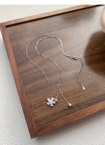 Close-up of S925 sterling silver necklace featuring a floral pendant with clear zircons