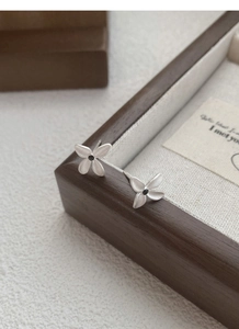 Detailed close-up of S925 sterling silver gardenia earrings with black zircon center