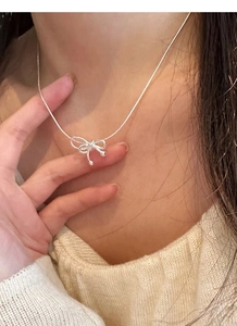 Détail du collier noeud en argent S925 avec perle d'eau douce sur le cou délicat