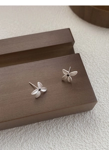Detailed macro view of S925 sterling silver gardenia earrings with matte texture