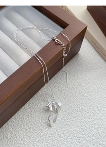 Vue détaillée du pendentif nœud en argent avec texture brossée et fine chaîne à billes