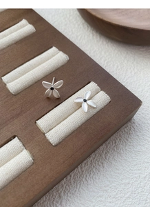 Macro shot of matte S925 sterling silver gardenia stud earrings with black center stones