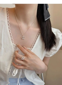 Close-up of S925 sterling silver pretzel heart jewelry set worn by a model
