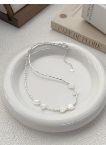 Détail du collier en argent S925 avec cœurs en nacre blanche et perles argentées