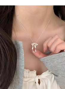 Gros plan du collier nœud en argent sterling S925 avec perle sur le cou d'un mannequin