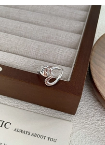 Macro view of polished S925 sterling silver heart ring on a velvet display tray