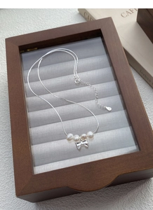 Détail du pendentif nœud en argent S925 avec perles d'eau douce et chaîne serpent