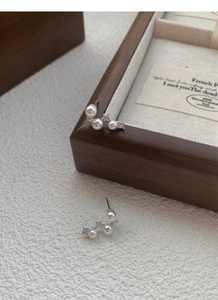 Detail of S925 silver pearl earrings with zircons in a curved Big Dipper design