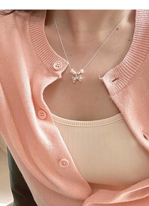 Gros plan d'un collier nœud en argent S925 avec perles d'eau douce sur cou