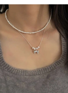 Détail du collier double en argent S925 avec pendentif nœud et perles d'eau douce