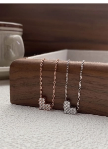 Macro detail of S925 sterling silver heart necklaces in rose gold and silver finishes
