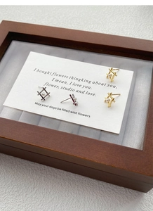 Macro shot of geometric square pearl stud earrings in gold and silver finishes