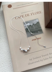 Détail macro du pendentif nœud en argent S925 avec perles d'eau douce naturelles