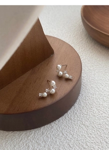 Macro detail of S925 sterling silver curved earrings with white pearls and zircons