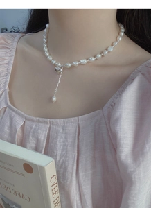 Dettaglio del pendente a cuore in argento S925 e collana di perle barocche su clavicola