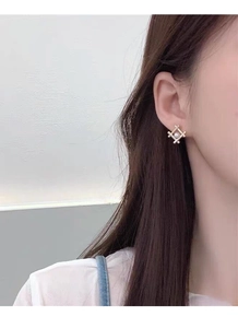 On-ear shot of geometric gold frame pearl stud earrings for a minimalist look