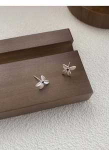 Close-up of S925 sterling silver gardenia stud earrings with matte brushed finish and black core