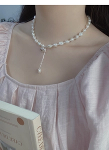 Dettaglio della collana di perle barocche in argento S925 a cuore indossata da una modella