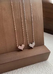 Close-up of S925 silver heart necklaces in rose gold and silver finishes with pavé stones
