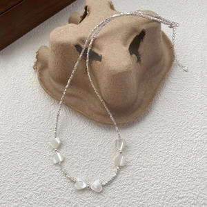 Collier en argent sterling S925 avec pendentifs cœur en nacre sur plateau rustique
