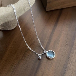 Minimalist S925 silver necklace with light blue round gemstone pendant on wood