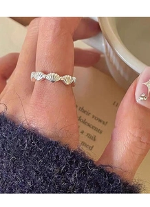 Detail of S925 sterling silver shell design ring worn by model in a cozy lifestyle setting