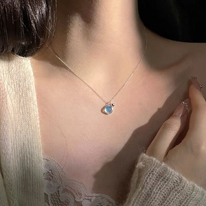 Elegant S925 sterling silver necklace with light blue round gemstone on a model